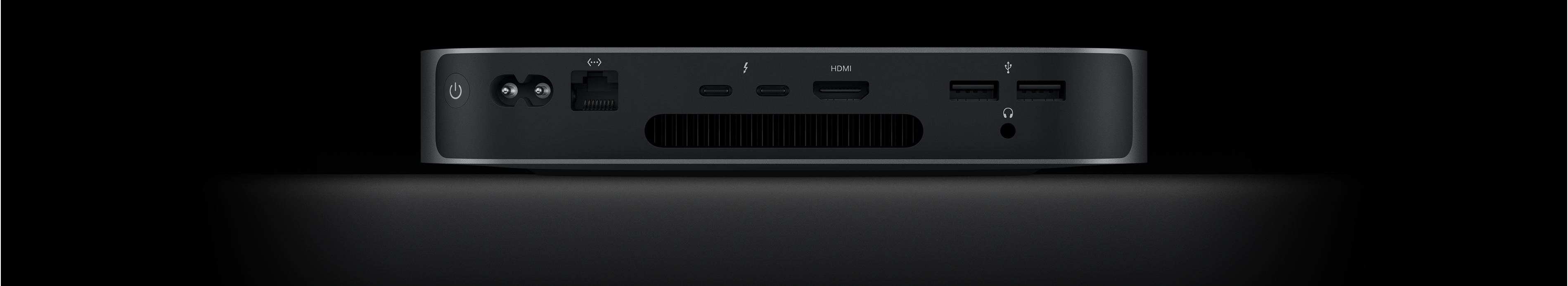 Mac mini sett fra baksiden vises med to Thunderbolt 4-porter, HDMI-port, to USB-A-porter, hodetelefonutgang, Gigabit Ethernet-port, strøminntak og av/på-knapp.